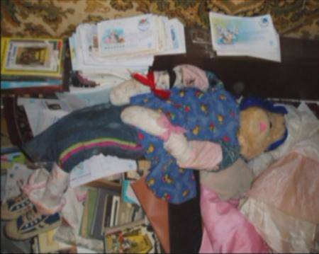 A still image taken from undated police footage shot inside the flat of Anatoly Moskvin shows books, clothes and dressed figures, reportedly mummified bodies desecrated from cemeteries